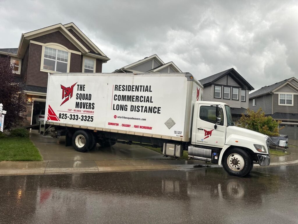 The Squad Movers branded moving truck parked at a residential job site in Edmonton