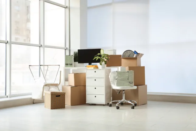 Office furniture and moving boxes in a bright empty office