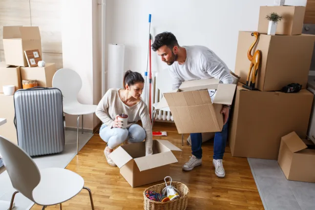 Couple packing moving boxes in their living room